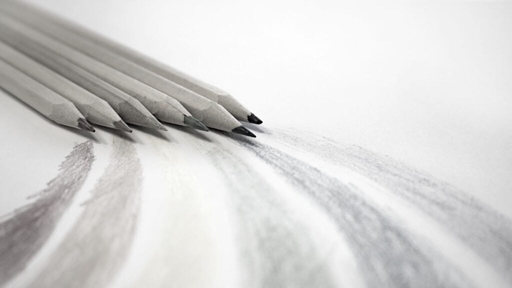 Alguns lápis riscando o papel, ilustrando o que é desenhar.