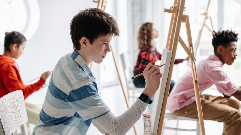Pessoas desenhando numa escola de arte, ilustrando uma análise de desenhos.