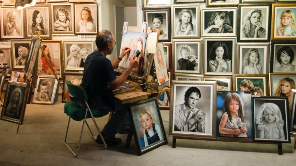Um homem com vários quadros ilustrando a arte realista.