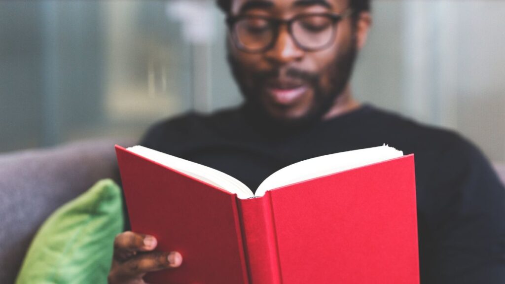 Um homem lendo um livro, ilustrando frases e textos sobre arte.