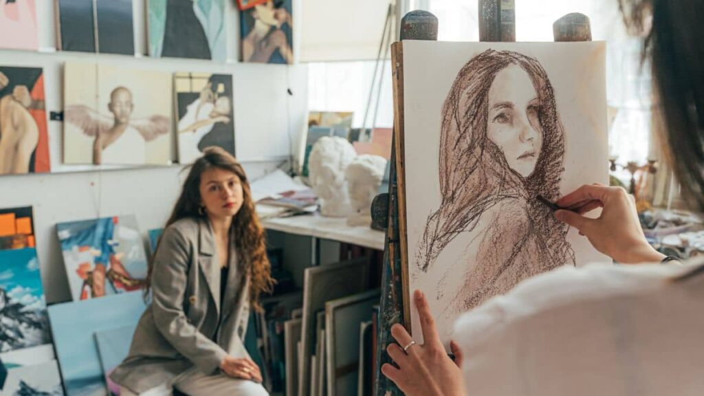Uma desenhista desenhando uma cliente ao vivo, ilustrando o que é trabalhar com desenhos.