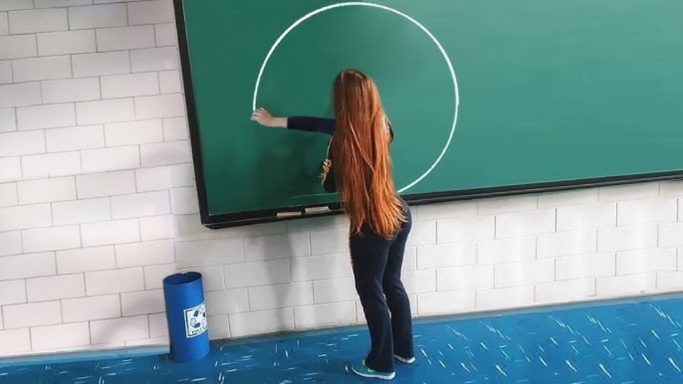 Uma mulher desenhando um círculo perfeito em um quadro, ilustrando o que é talento para desenhar.